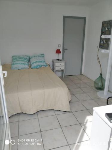 une chambre avec un lit et un sol carrelé dans l'établissement Maison proche des plages et du marché de Noël, à Alénya