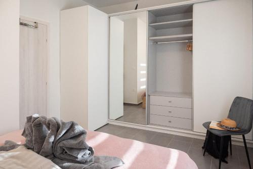 a bedroom with a closet and a chair and a mirror at Harmony in Perea