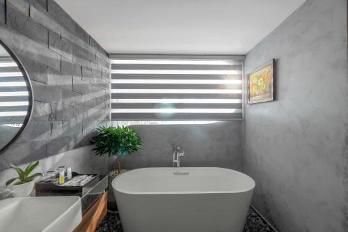 a bathroom with a white tub and a sink at Anh Nguyen Oceanfront Luxury Villas Nha Trang in Nha Trang