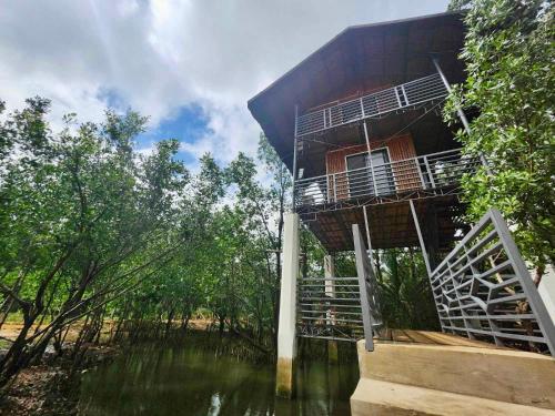a building sitting on top of a body of water at Tree House in Mahuyabhuyab
