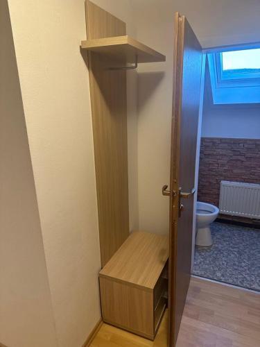 a bathroom with a toilet and a wooden door at Wohnung Remshalden Grunbach in Remshalden