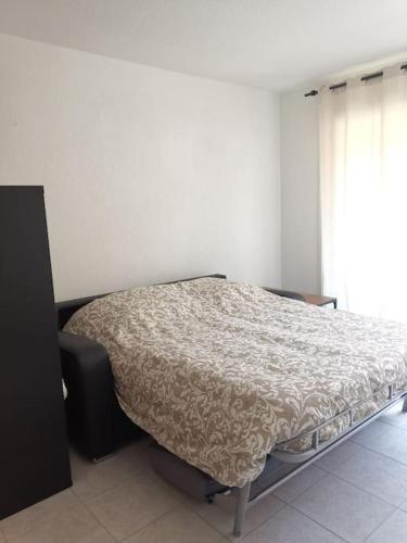 une chambre avec un lit dans une pièce avec une fenêtre dans l'établissement Studio grande terrasse proche gare et mer, à Menton