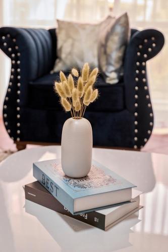 a vase sitting on top of books on a coffee table at The beautiful Shams AO9 in Entebbe