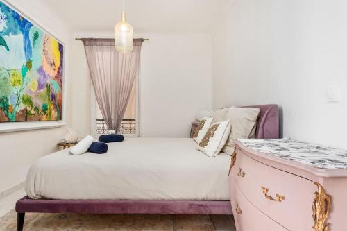 ein Schlafzimmer mit einem Bett und einem Gemälde an der Wand in der Unterkunft Belle époque in Beausoleil