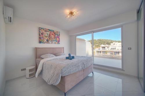 une chambre avec un lit et une grande fenêtre dans l'établissement Coco - Spacieux - Luxueux - VCA, à Cannes