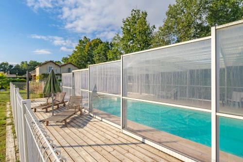 une piscine avec une clôture et des chaises sur une terrasse en bois dans l'établissement Royan, à Saint-Simon-de-Bordes