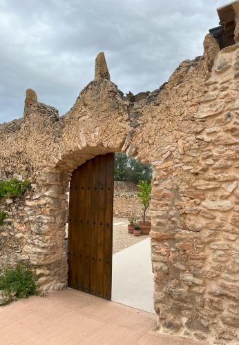 an entrance to a stone building with a wooden door at Mas de Muntaner in Tivissa