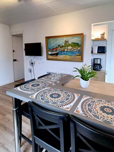 une table de salle à manger avec une nappe dessus dans l'établissement Appartement à côté du port de Ploumanac'h, à Perros-Guirec