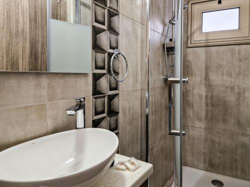 a bathroom with a white sink and a shower at Andre Marie Stonewood Retreat in Limassol