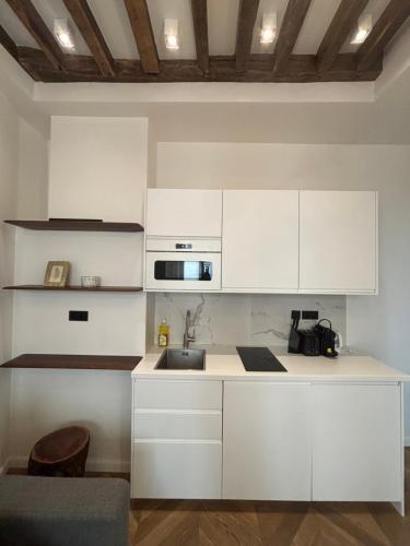 une cuisine avec des armoires blanches et un évier dans l'établissement Central Studio Tronchet, à Paris