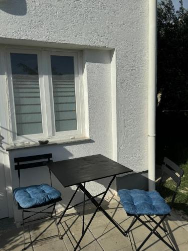 a table and two chairs in front of a window at Apartments Marija with big garden - TA Leut Agency in Vrsi
