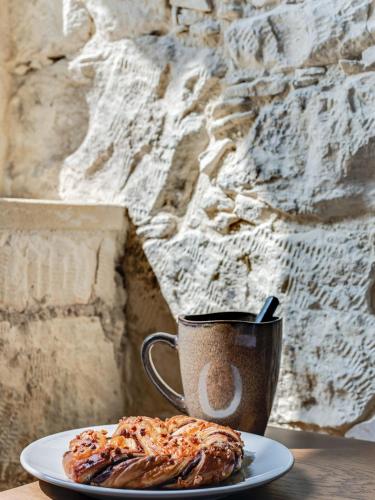 a plate with a pastry and a cup of coffee at Andre Marie Stonewood Retreat in Limassol