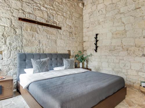 a bedroom with a large bed in a stone wall at Andre Marie Stonewood Retreat in Limassol