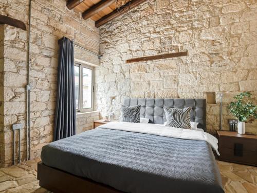 a bedroom with a large bed in a stone wall at Andre Marie Stonewood Retreat in Limassol