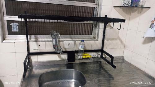a metal sink in a room with a mirror at CASA sobrado edícula aconchegante in São Paulo