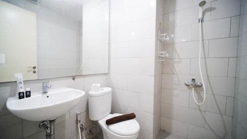 a bathroom with a toilet and a sink and a shower at Spacious 2BR Connected to Mall at Anderson Supermall Mansion Apartment By Travelio in Surabaya