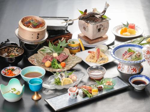 a table with many plates of food on it at Hita Onsen Kizantei Hotel in Hita