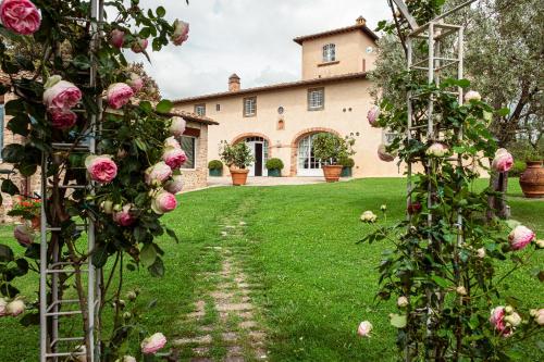 a garden in front of a house with roses at Villa La Fornace in Tavarnelle in Val di Pesa