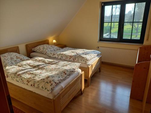 two twin beds in a room with a window at Bauernhof Sesterhenn in Leichlingen