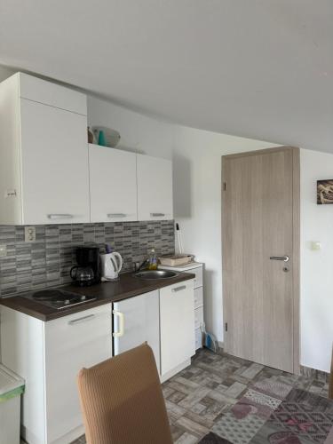 a kitchen with white cabinets and a counter top at Apartments Marija with big garden - TA Leut Agency in Vrsi