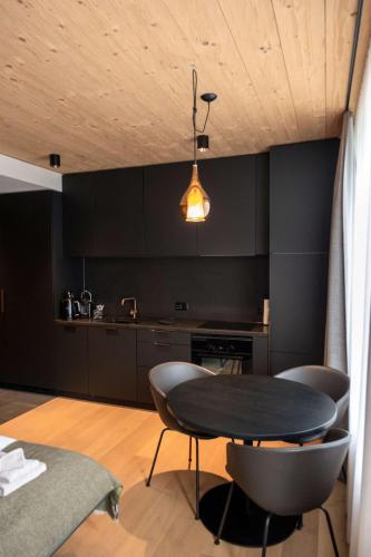 a kitchen with black walls and a table and chairs at Andermatt Alpine Apartments in Andermatt