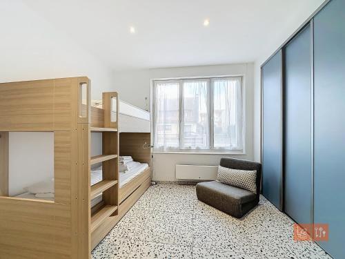 une chambre avec un lit, une chaise et une fenêtre dans l'établissement Les Lutins - sur la plage, à Wimereux