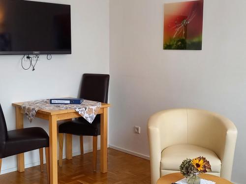 a room with a table and two chairs and a television at Bauernhof Sesterhenn in Leichlingen