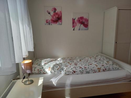 a bed in a bedroom with two pictures on the wall at Bauernhof Sesterhenn in Leichlingen