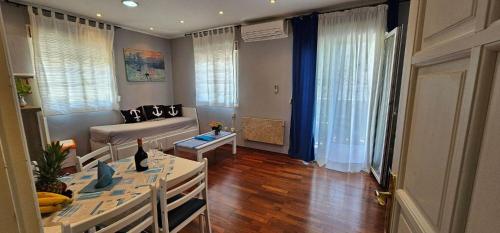 a living room with a table and a couch at Apartments Tena in Rovinj