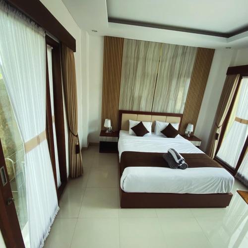 a hotel room with two beds and a phone on the bed at SONGOKU HOUSE APARTMEN in Pesanggaran