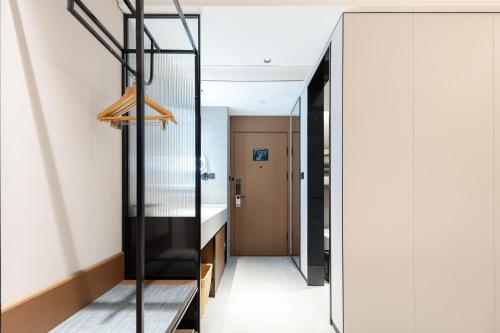 a hallway with a glass door leading to a bedroom at Atour Hotel Xiamen Huli Nanshan Road in Xiamen
