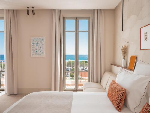 a bedroom with a bed and a view of the ocean at Hôtel Liautaud Rooftop Cassis in Cassis
