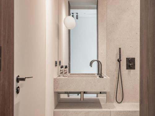 a bathroom with a sink and a mirror at Hôtel Liautaud Rooftop Cassis in Cassis