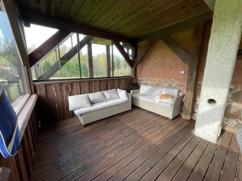 an attic room with two couches on a wooden deck at Salu Jahimaja in Soontaga