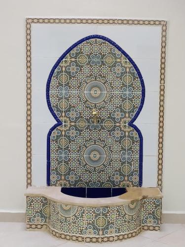 a fountain in front of a wall with a pattern on it at Maison d'hôte Najah 1 in Khenifra