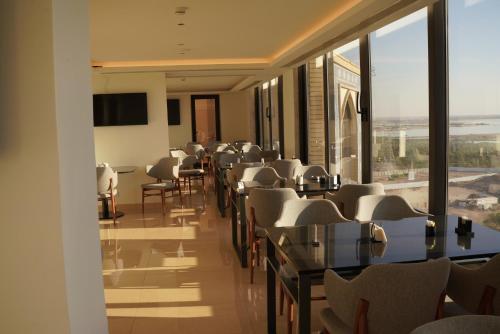 a conference room with tables and chairs and a large window at Nassim Al Najaf Hotel in An Najaf