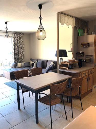 un salon avec une table, des chaises et un canapé dans l'établissement La Cigale, à Manosque