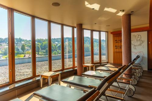 a row of tables and chairs in a room with windows at Hotel Balnea Superior - Terme Krka in Dolenjske Toplice