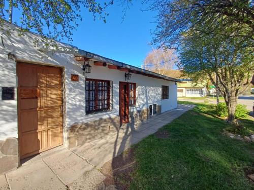 a white house with a garage and a yard at Abi in Esquel