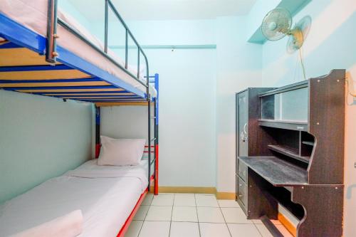 a small room with a bunk bed and a desk at Comfort and Cozy Living 2BR at Cibubur Village Apartment By Travelio in Depok