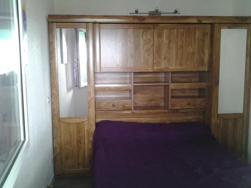 una cama en una habitación con una pared de madera en MAGNIFIQUE VUE MER et PHARE DE CORDOUAN, en Saint-Palais-sur-Mer