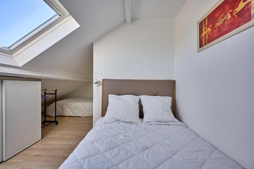 une chambre avec un lit et une fenêtre dans l'établissement Les Jardins du Val Pican - Appt proche de la mer, à Courseulles-sur-Mer