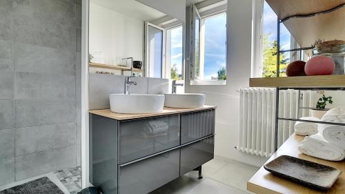 une salle de bain avec deux lavabos et une fenêtre dans l'établissement Maison Cozy - Au calme avec terrasse, à Cholet