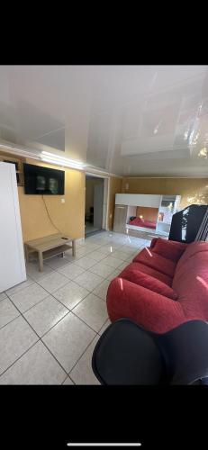 - un salon avec un canapé rouge dans l'établissement Agréable Dortoir en bord de jardin Lit 1, à Castres