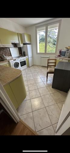 Il comprend une cuisine dotée de carrelage et d'une fenêtre. dans l'établissement Agréable Dortoir en bord de jardin Lit 1, à Castres