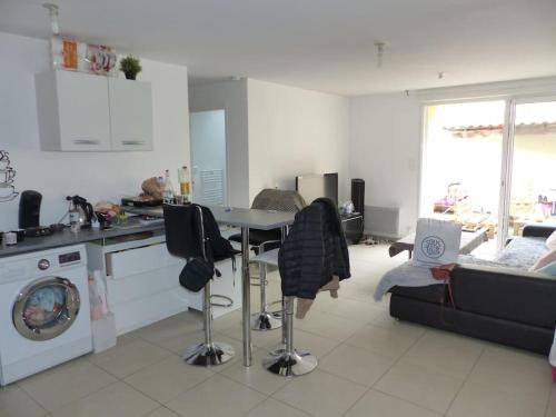 une cuisine et un salon avec une table et des chaises dans l'établissement Maison proche aéroport, à Saint-Aignan-Grand-Lieu