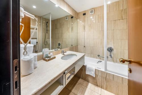 a bathroom with a sink and a large mirror at Abacus Hotel in Sesto San Giovanni