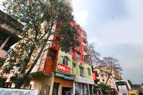 a red and yellow building on the side of a street at Super Hotel O Adri Hotels in Kolkata