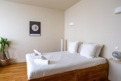 - une chambre avec un lit doté de draps blancs et d'oreillers blancs dans l'établissement The Charming Saint Honoré, à Paris