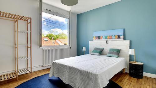 une chambre avec un lit et une grande fenêtre dans l'établissement Maison Cozy - Au calme avec terrasse, à Cholet